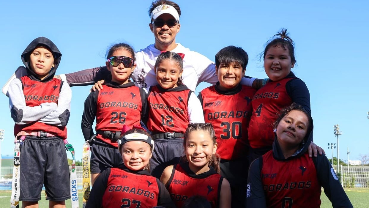 Jugadores de Dorados Mérida categoría U10 posando junto a su entrenador tras un partido de flag football
