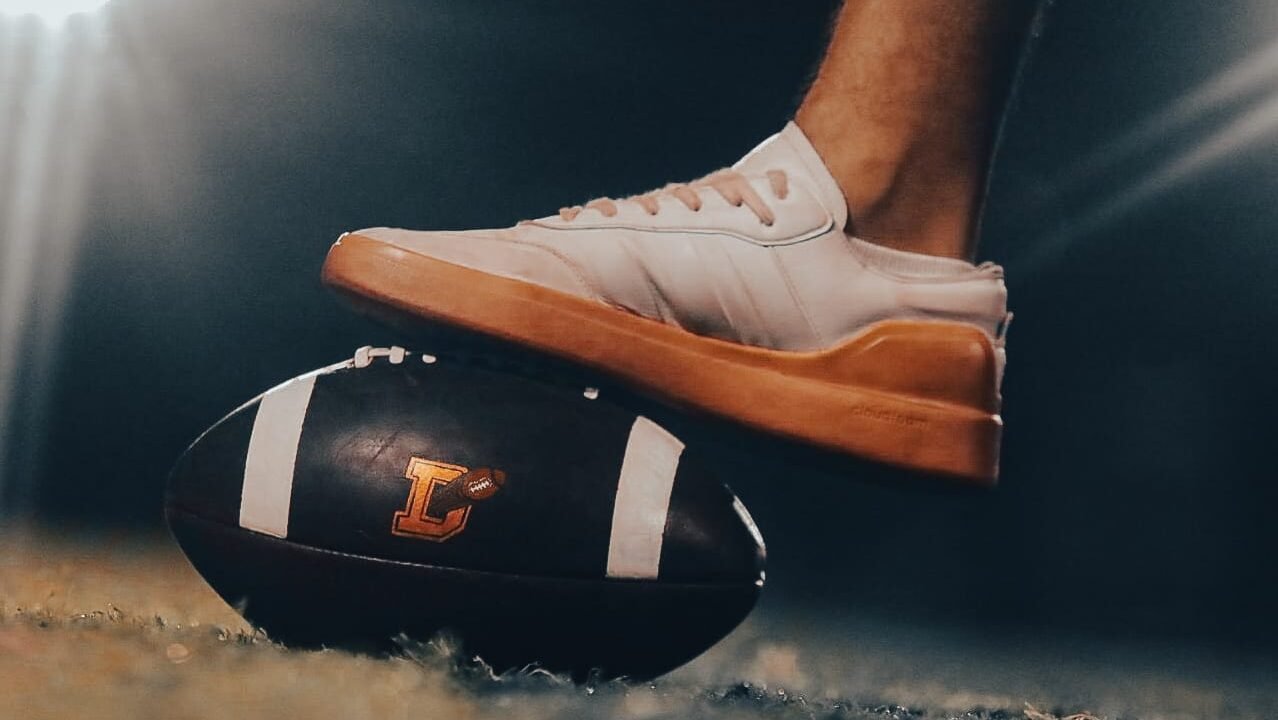 Balón de flag football con logo de Dorados Mérida y un jugador preparándose para iniciar jugada